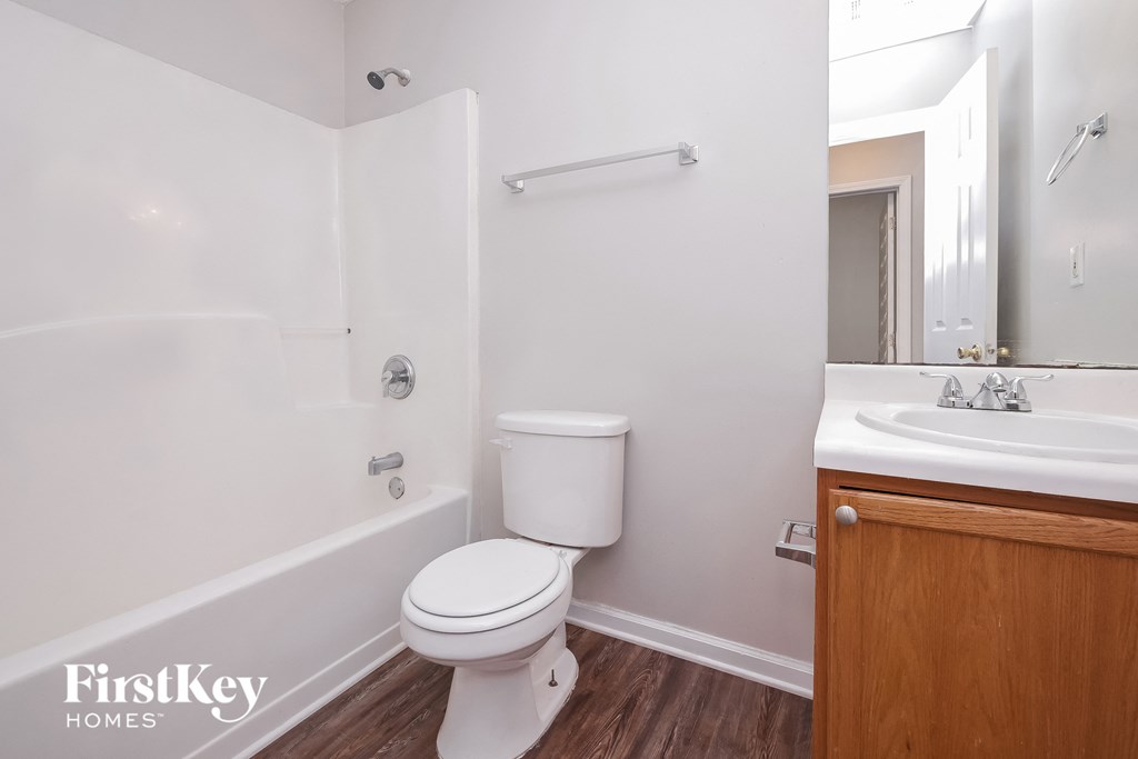 a bathroom with a toilet and a sink and a bath tub