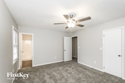 a living room with carpet and a ceiling fan