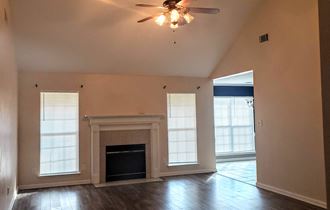 a living room with a fireplace and a ceiling fan