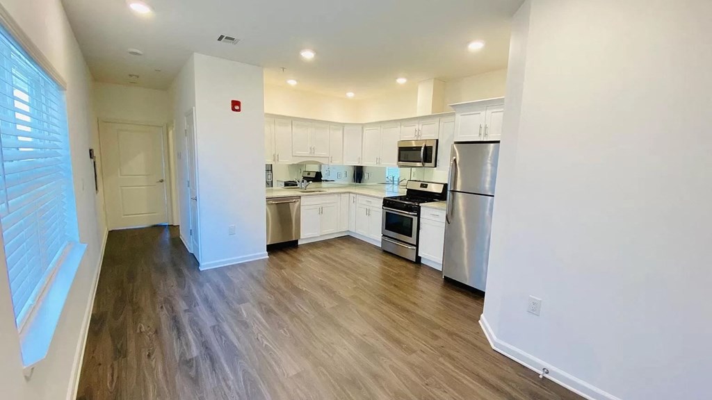 a kitchen with white cabinets and stainless steel appliances