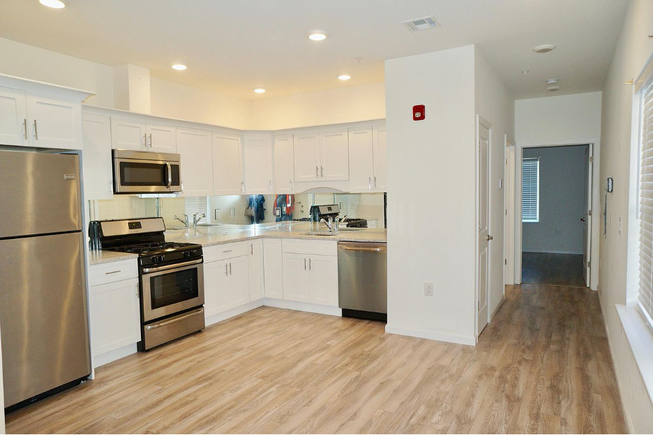 a kitchen with white cabinets and stainless steel appliances
