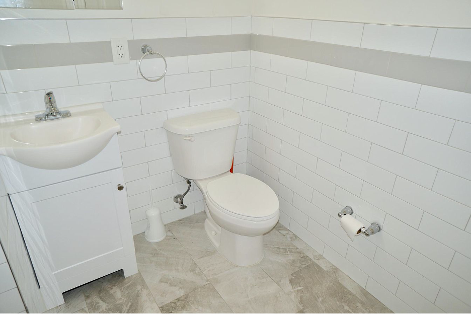 a white bathroom with a toilet and a sink
