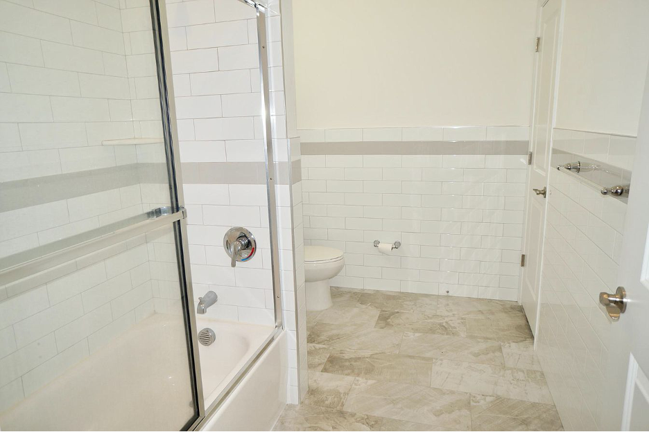 a white bathroom with a shower and a toilet