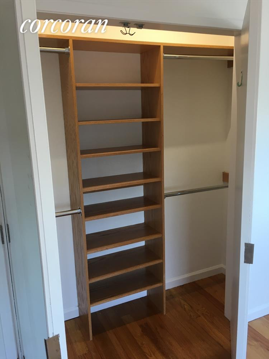 A tall wooden shelf unit with many shelves is in a room.