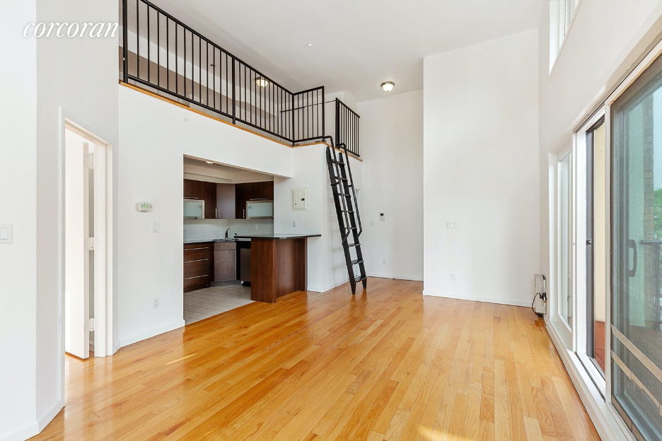 A wooden floor in a white room with a black railing.