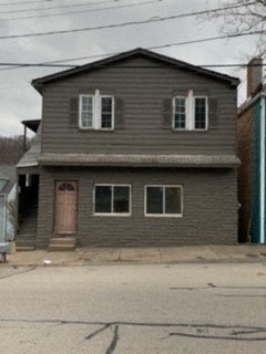 a gray house with two windows and a door