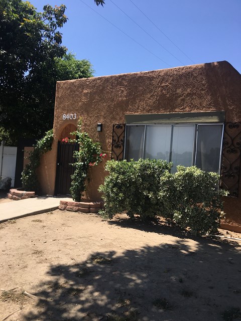 a building with a door and bushes in front of it