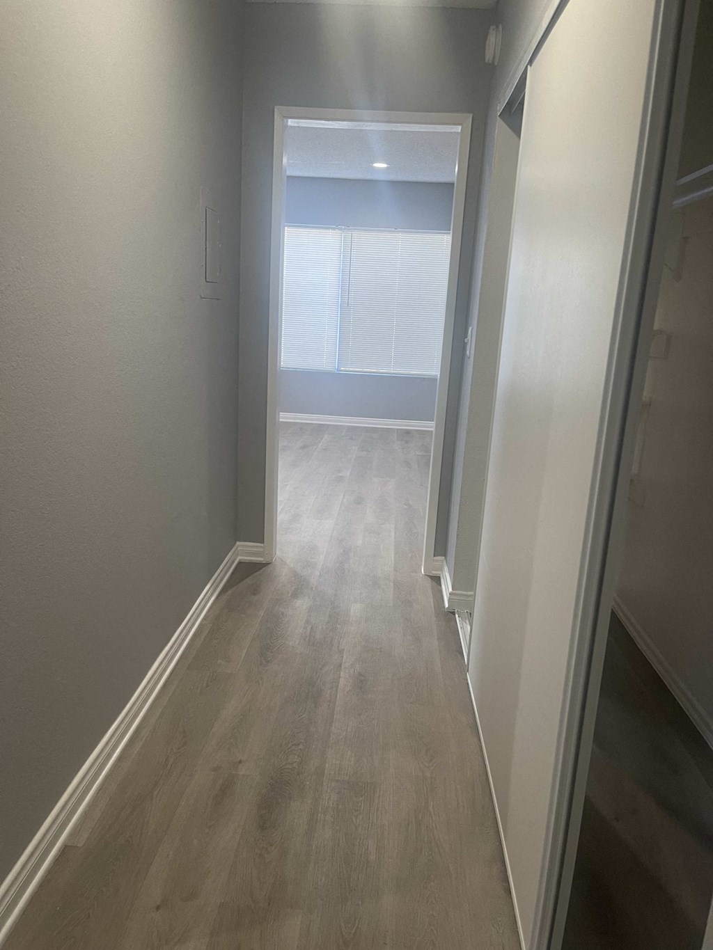 a hallway with wooden floors and white walls and a white door