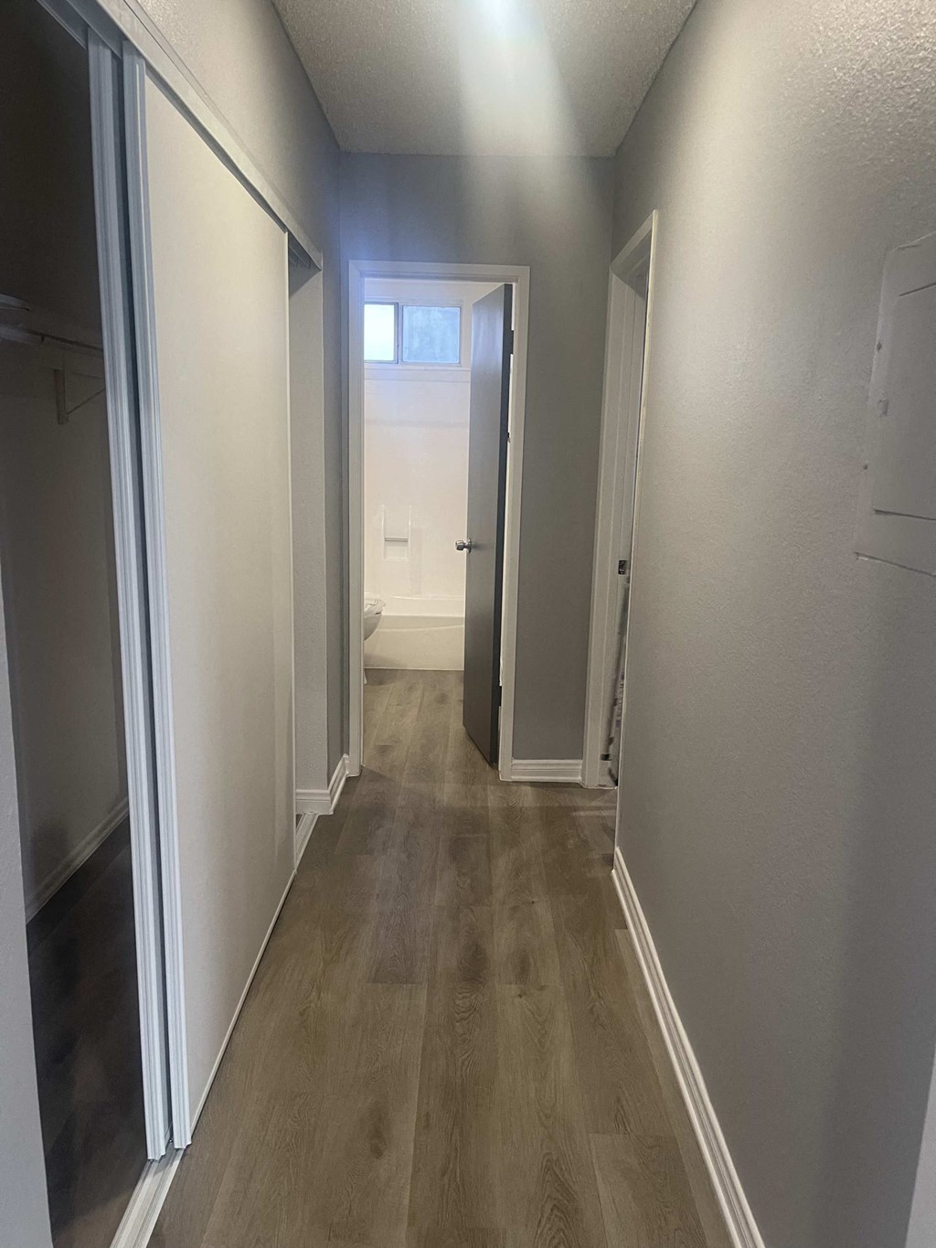 a hallway with a door open to a bathroom and a closet