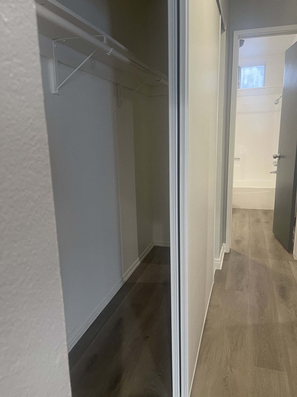 a walk in closet in a bathroom with a sliding glass door