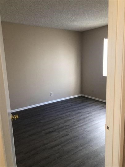 a empty room with wooden floors and a window