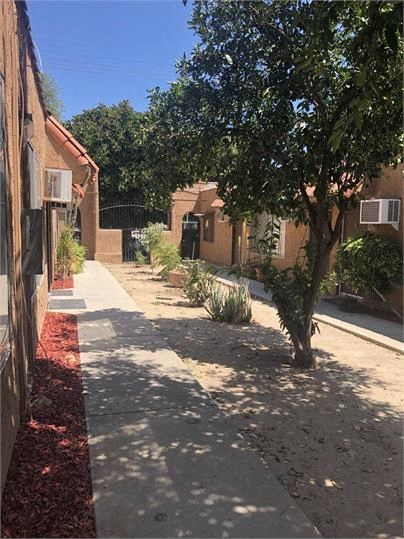 a sidewalk next to a building with trees