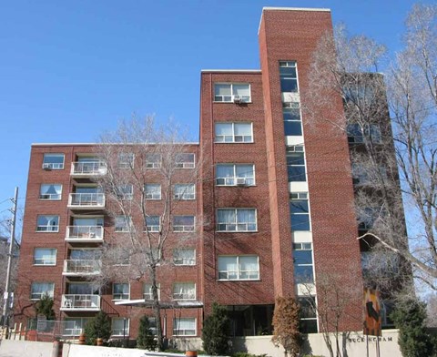 a red brick apartment building with trees in front of it