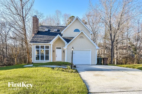 a white house with a white garage door and a driveway