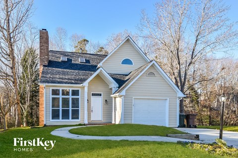 a white house with a white garage door and a lawn