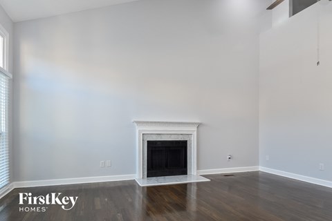 a living room with white walls and a fireplace