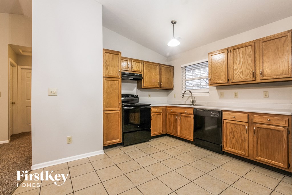 a kitchen with black appliances and wooden cabinets