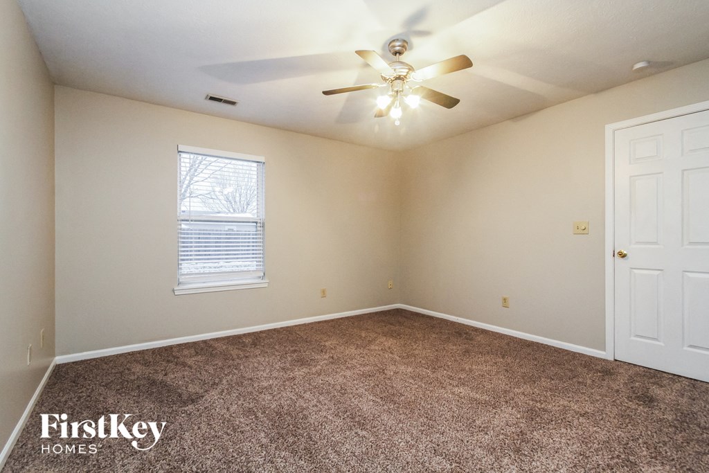 the master bedroom has a carpeted floor and a ceiling fan