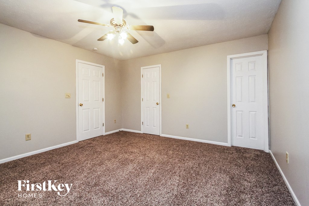 a empty room with two doors and a ceiling fan