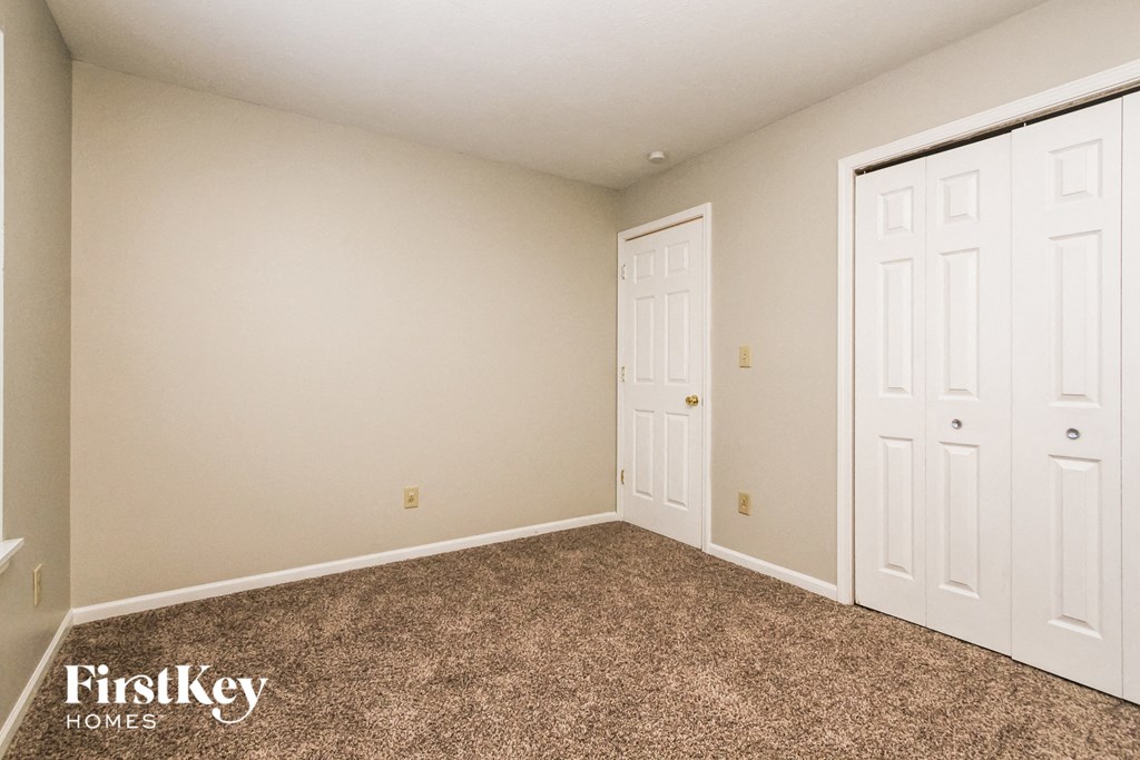 a bedroom with two closets and a carpeted floor