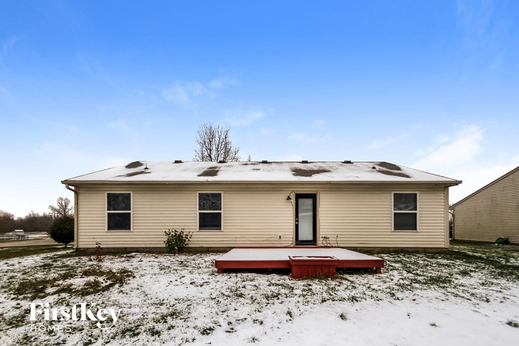 a home in the snow with a red deck