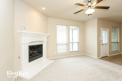 a living room with a fireplace and a ceiling fan