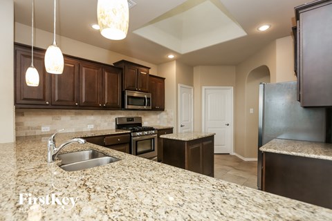 a kitchen with granite counter tops and wooden cabinets