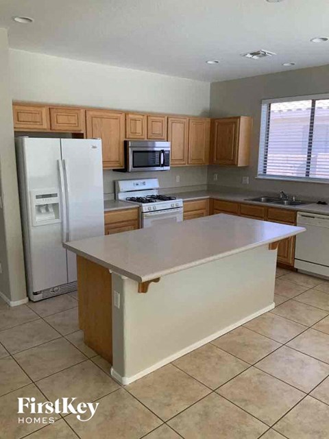 A kitchen with a white fridge, white stove, and white oven.