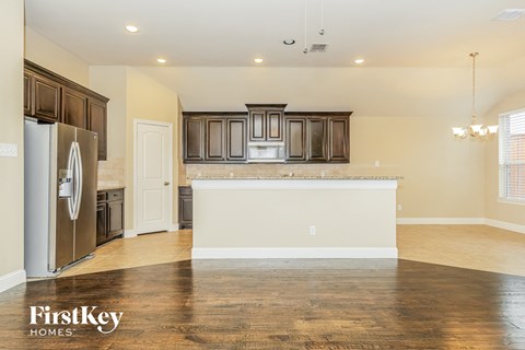 A kitchen with wooden cabinets and a refrigerator.