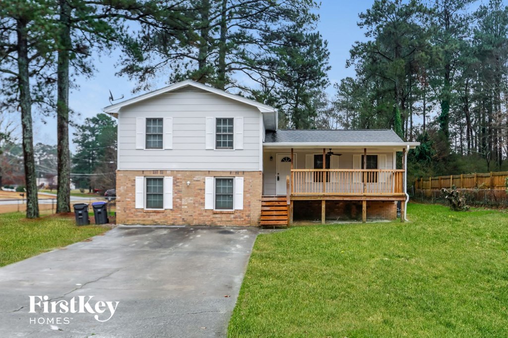 a white house with a porch and a driveway
