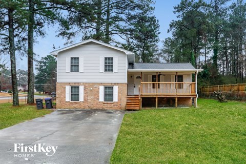a white house with a porch and a driveway