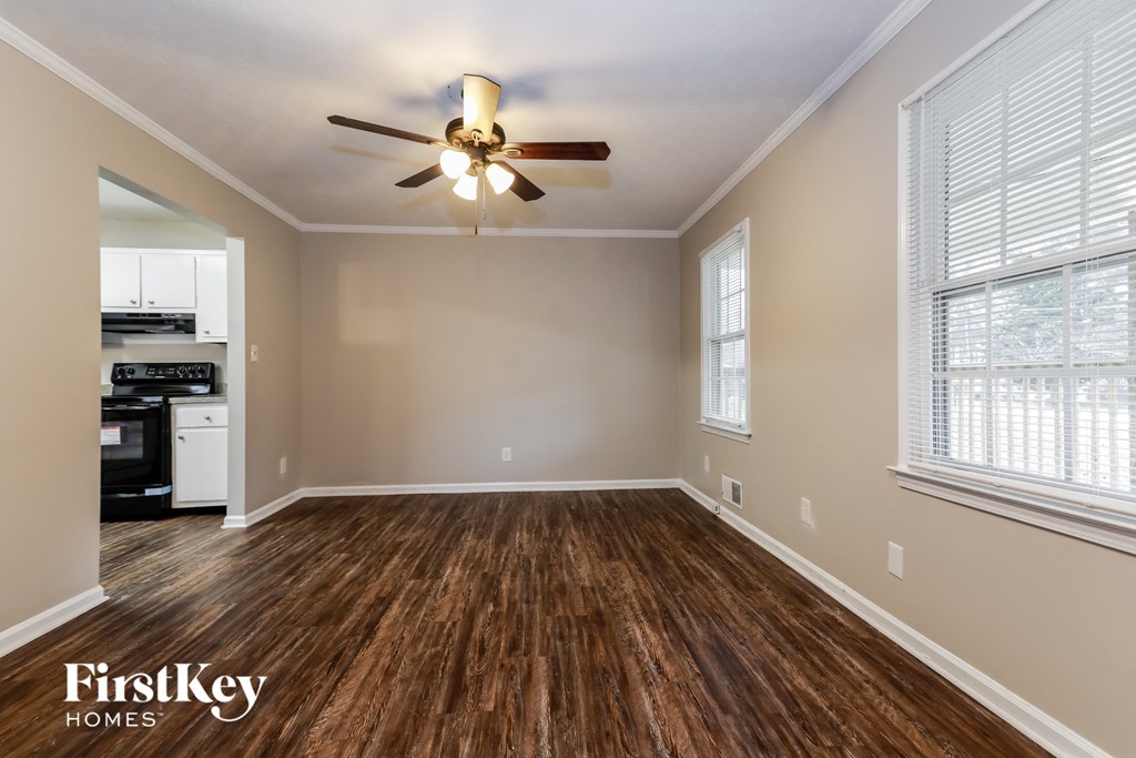 an empty living room with wood flooring and a ceiling fan