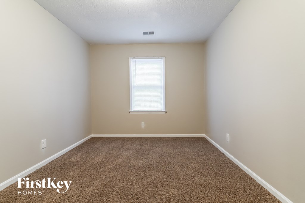 a empty room with carpet and a window