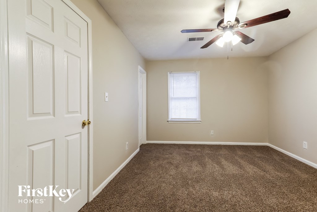 a bedroom with carpeted flooring and a ceiling fan