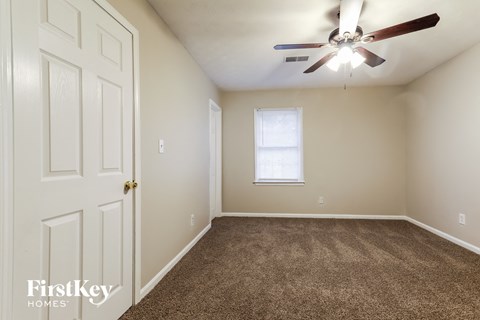 a bedroom with carpeted flooring and a ceiling fan