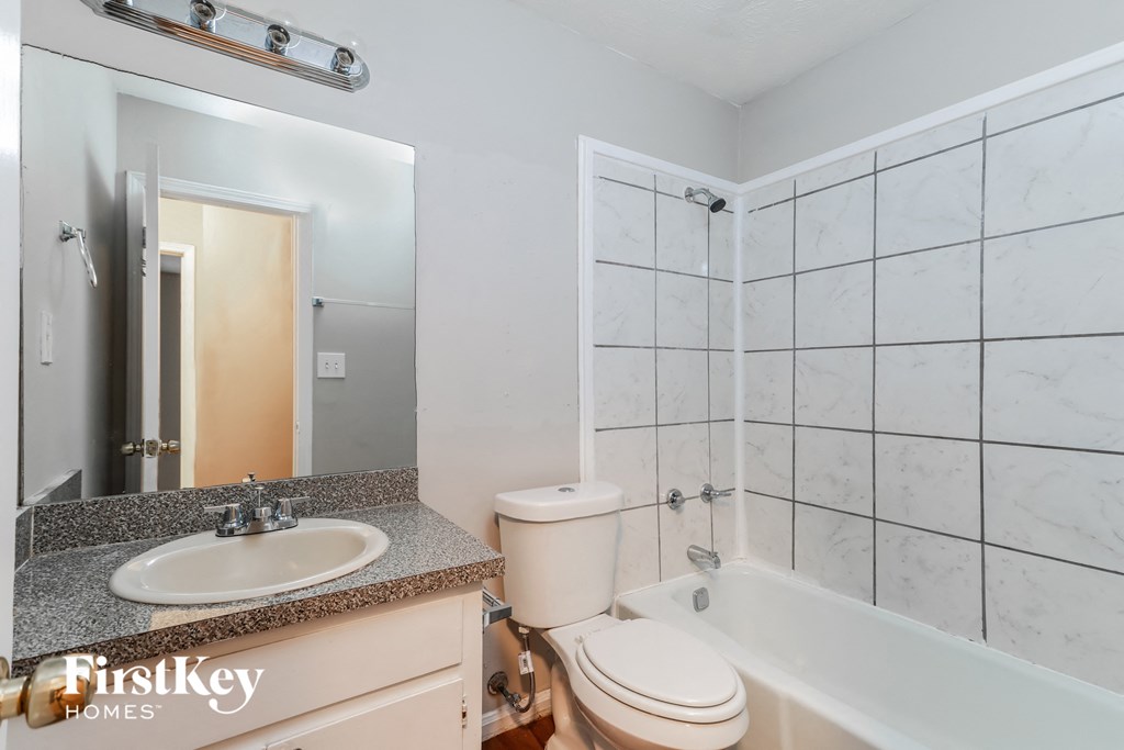 a white bathroom with a tub sink and toilet