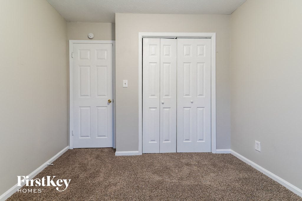 a bedroom with two white doors and a carpeted floor
