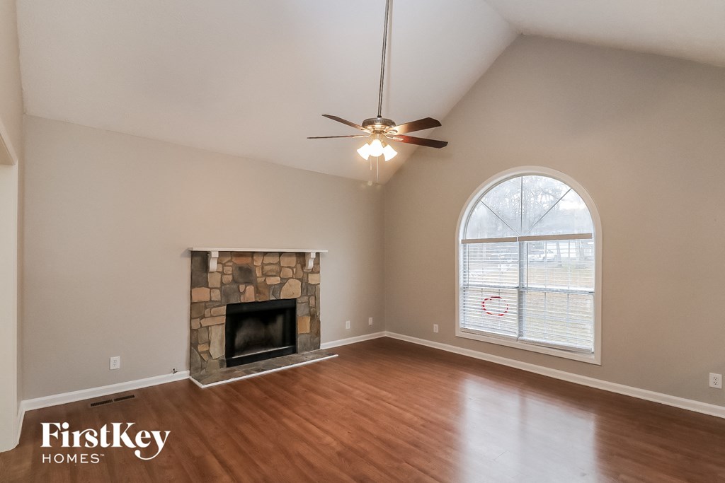 a living room with a fireplace and a ceiling fan