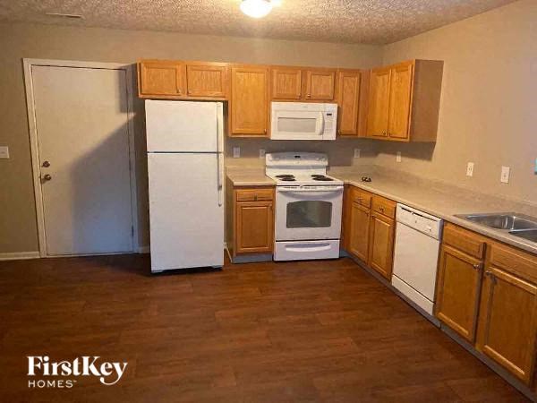 A kitchen with wooden cabinets and a white fridge.