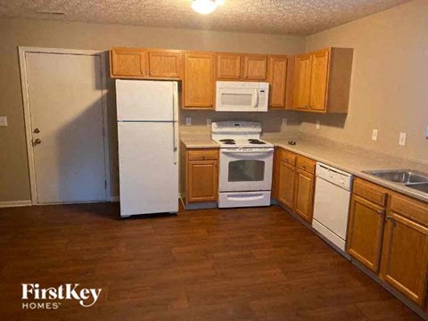 A kitchen with wooden cabinets and a white fridge.