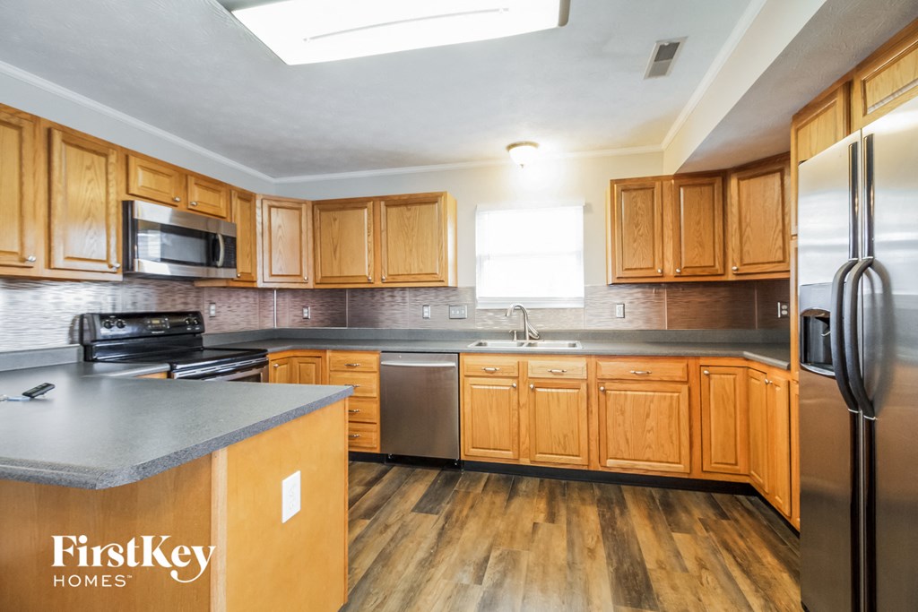 a kitchen with wooden cabinets and stainless steel appliances