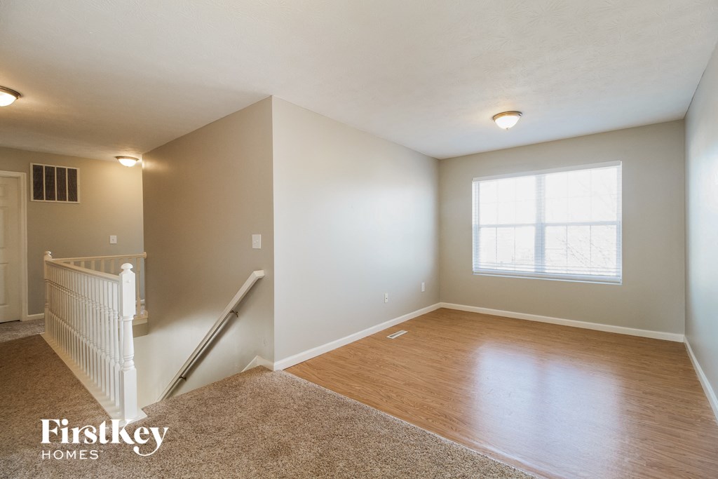 the living room and dining room with stairs to the bonus room