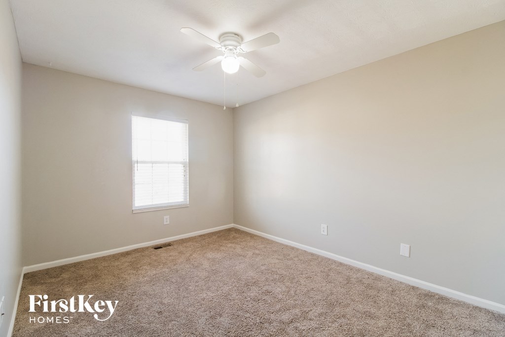 a bedroom with carpet and a ceiling fan