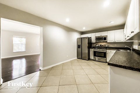 a large kitchen with stainless steel appliances and black counter tops