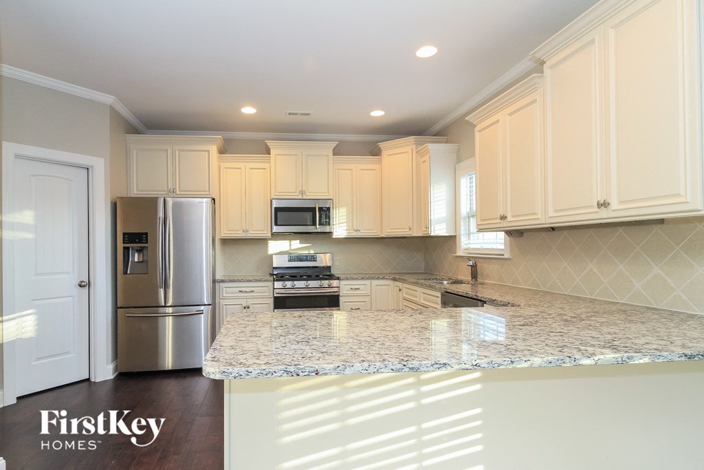 a kitchen with white cabinets and a granite counter top