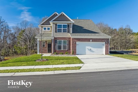 a brick house with a white garage door and a lawn