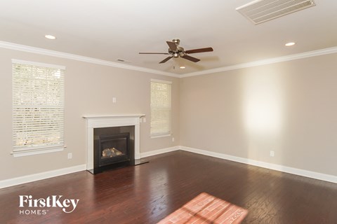 a living room with a fireplace and a ceiling fan