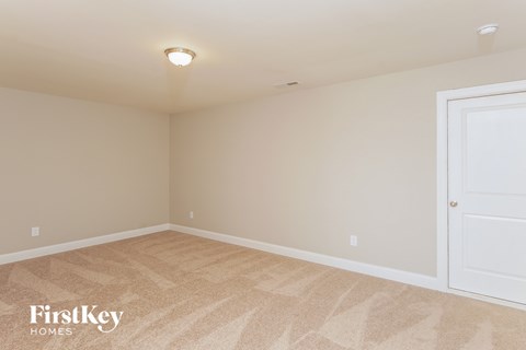 a bedroom with beige carpet and a white door