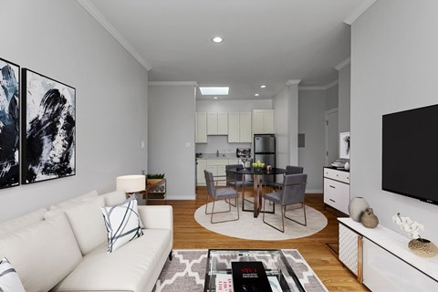 A modern living room with a white sofa and a black and white abstract painting on the wall.