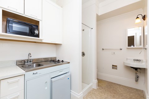 A small kitchen with a sink, dishwasher and microwave.